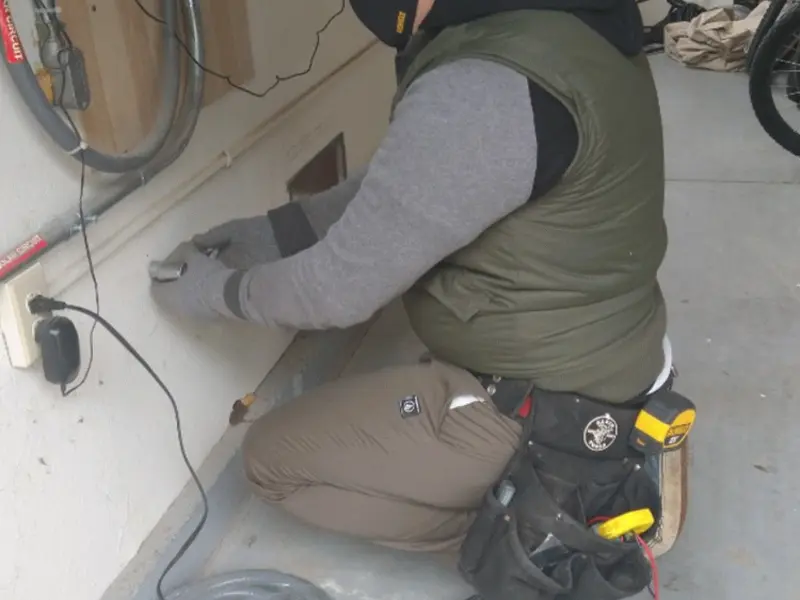 Electrician performing outlet wiring in a Wellford garage